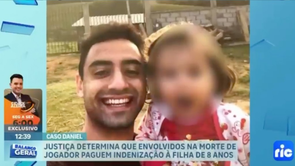 Daniel Corrêa Freitas ao lado da filha, com o rosto da criança preservado, em imagem da reportagem da RIC TV